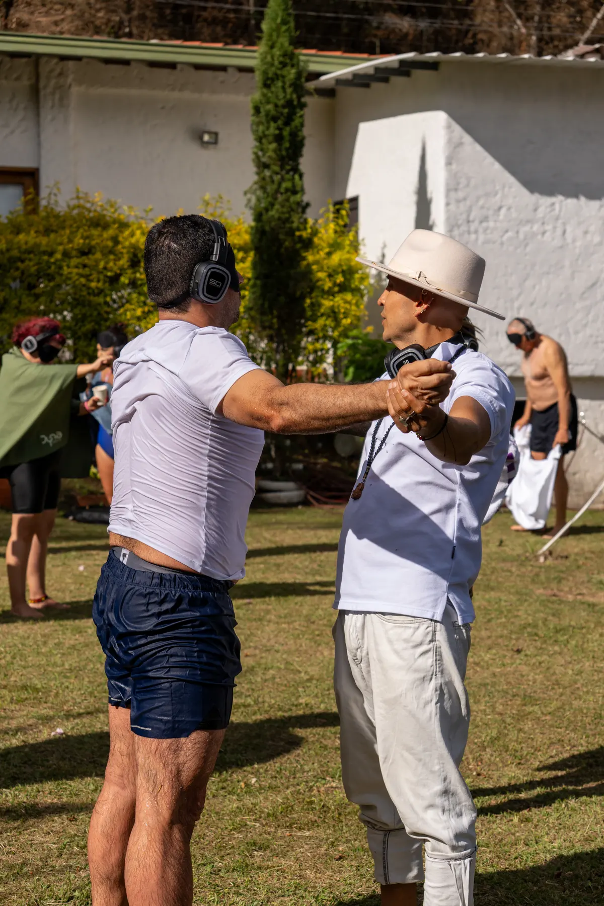 Dos participantes celebran con los brazos en alto en el jardín de la casa