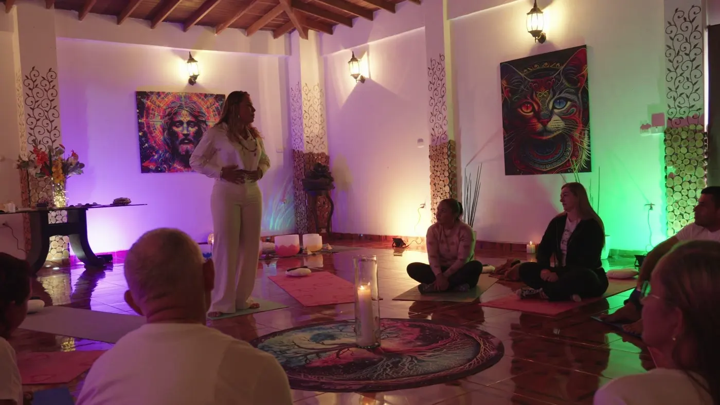 Círculo en el salón mientras una facilitadora habla de pie junto al mandala central