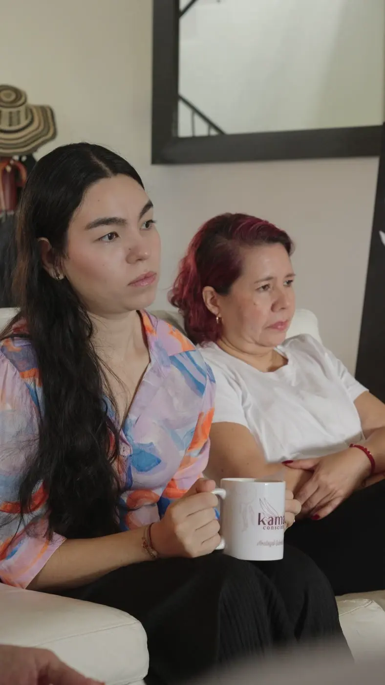Dos participantes conversan en la sala con un pocillo de café de KAMAEL