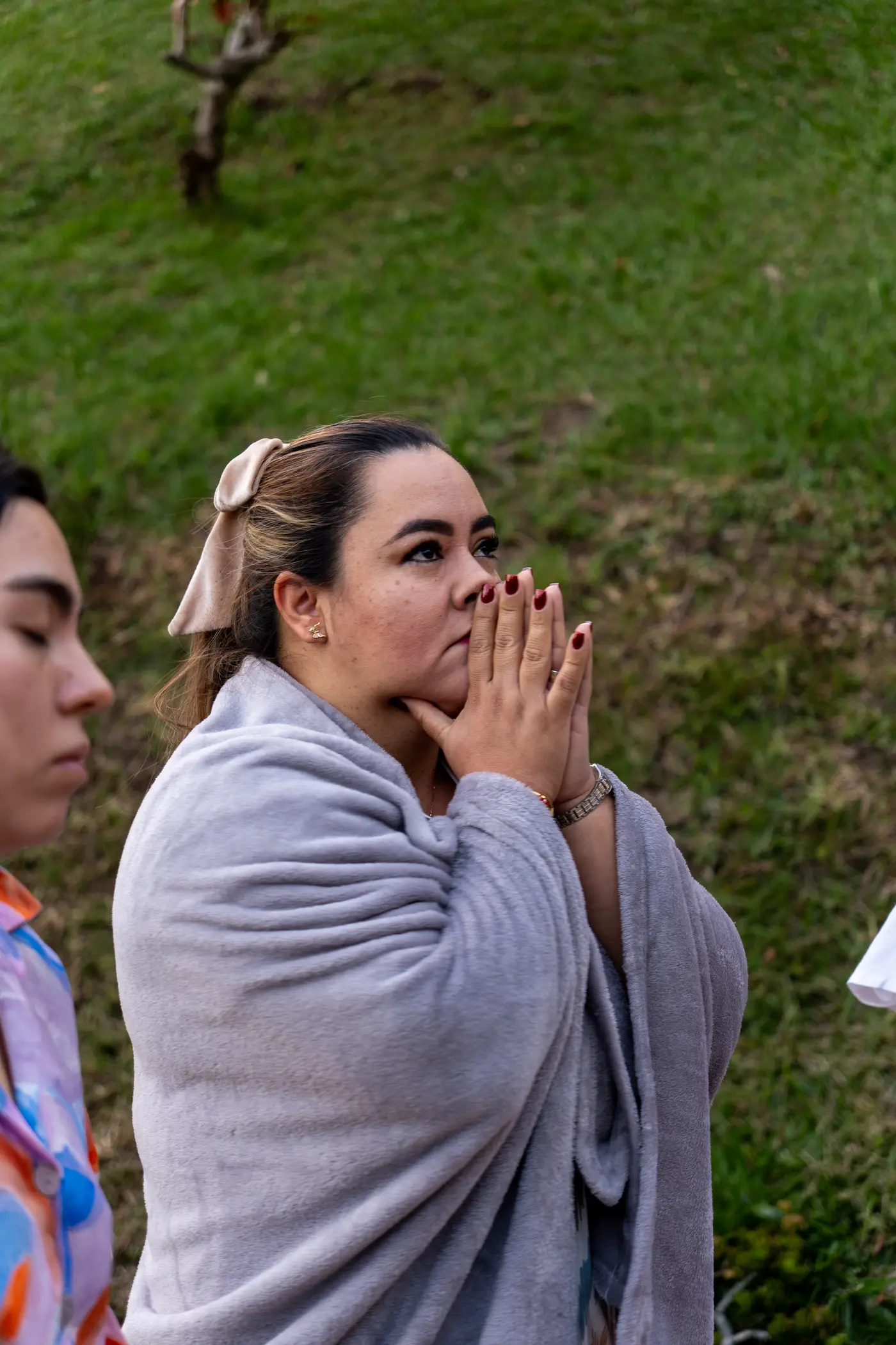 Una participante cubierta con una manta junta las manos al cierre del encuentro