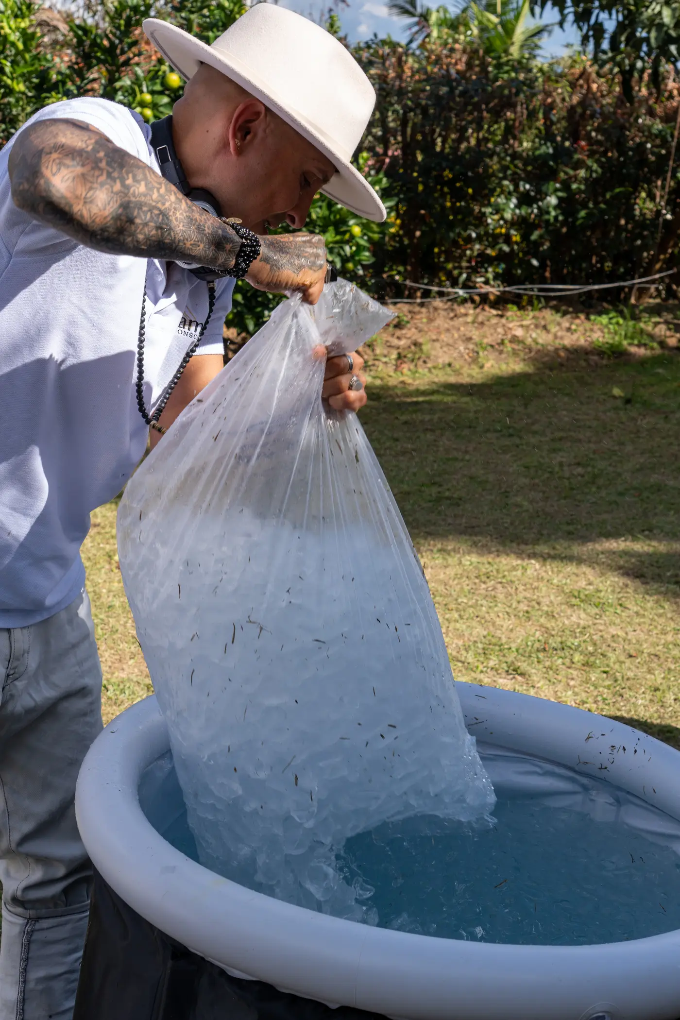 Un facilitador vacía una bolsa de hielo dentro de la tina de inmersión
